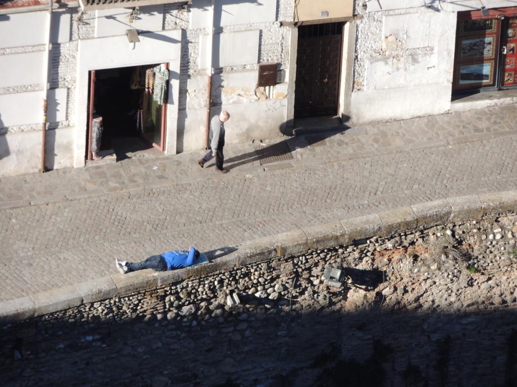 Some guy relaxing far below on the wall