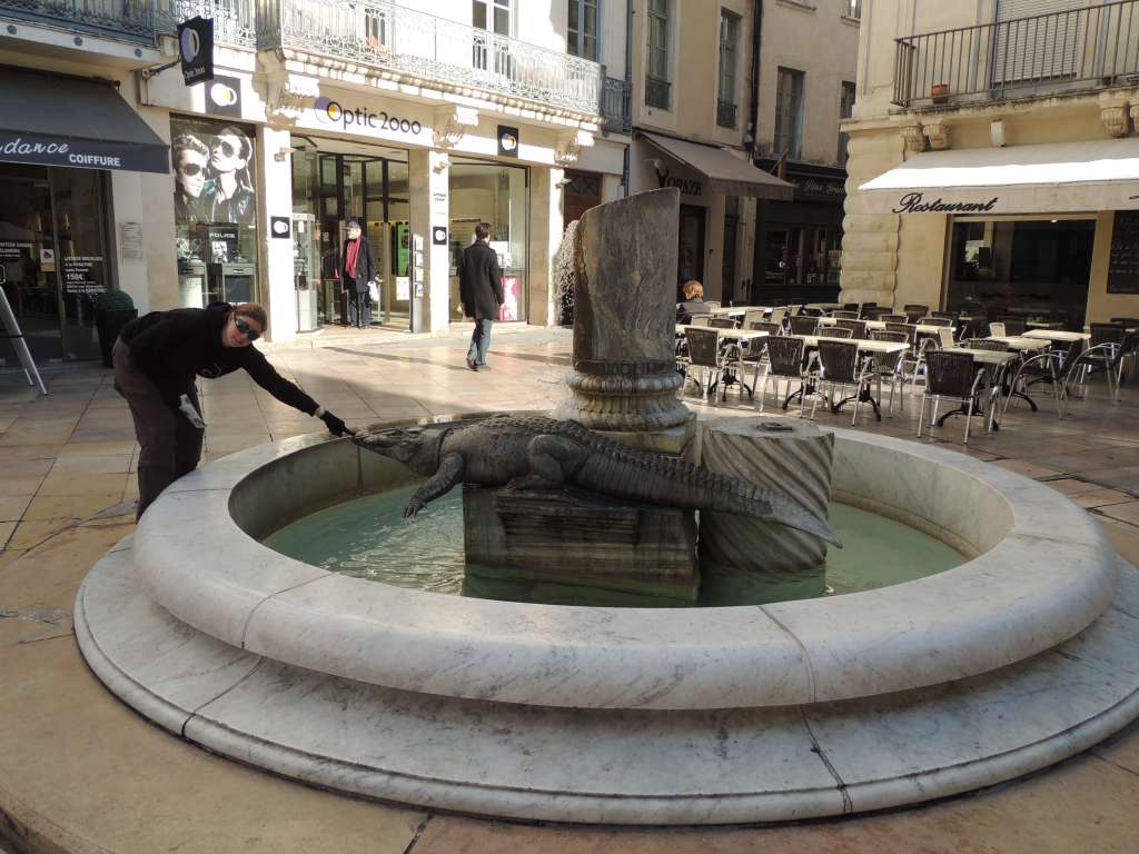 A fountain in the Place du Marché containing one of the cities emblems, the crocodile.