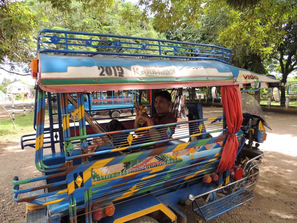 A tuktuk driver relaxing in the back on his hammock.